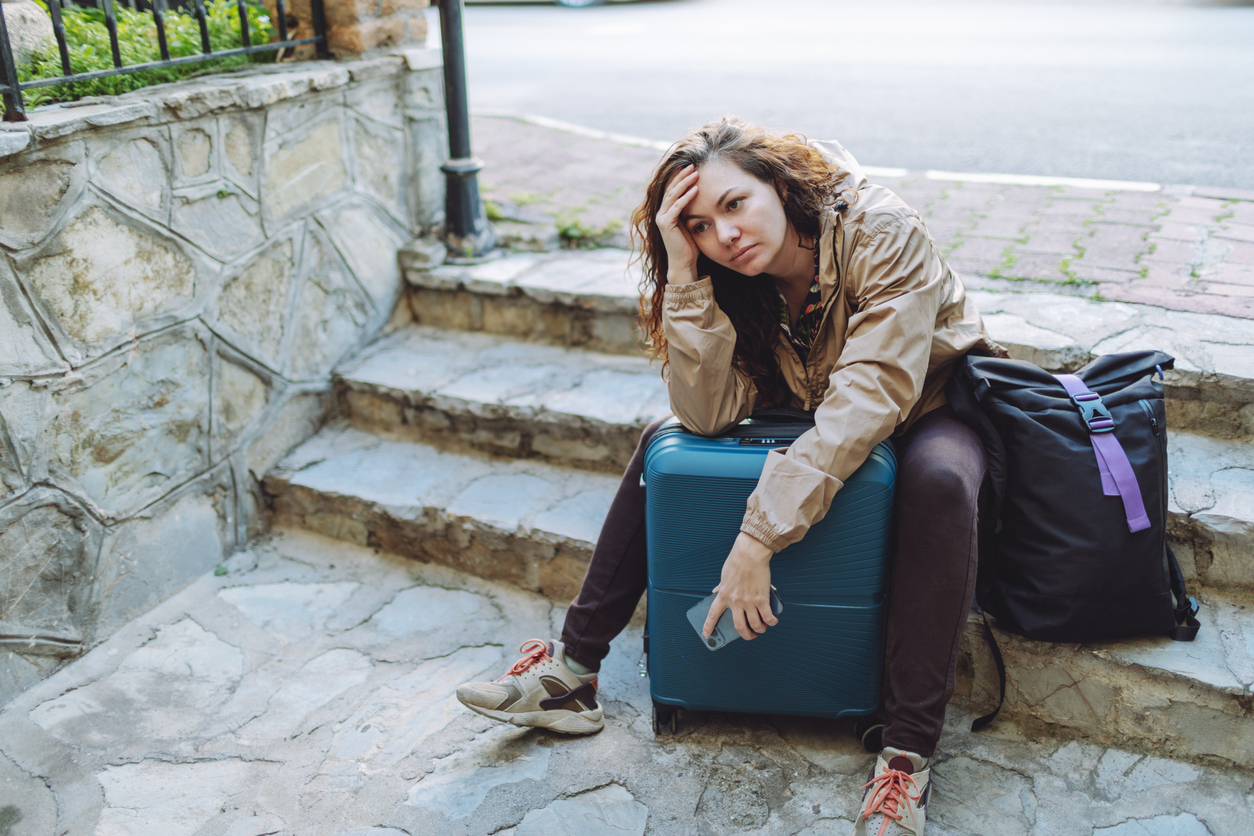 Traveler sitting outdoors with luggage